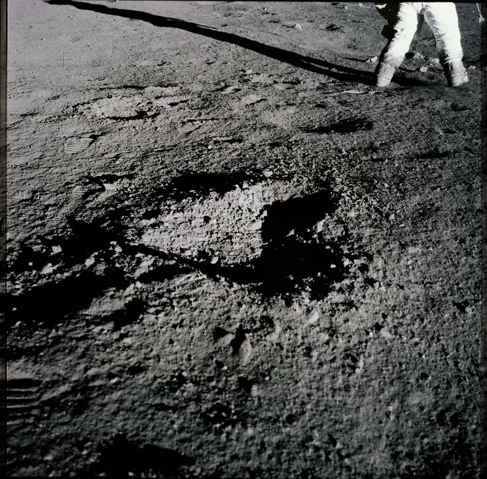 Superfície lunar cinzenta cheia de pequenas crateras e fragmentos